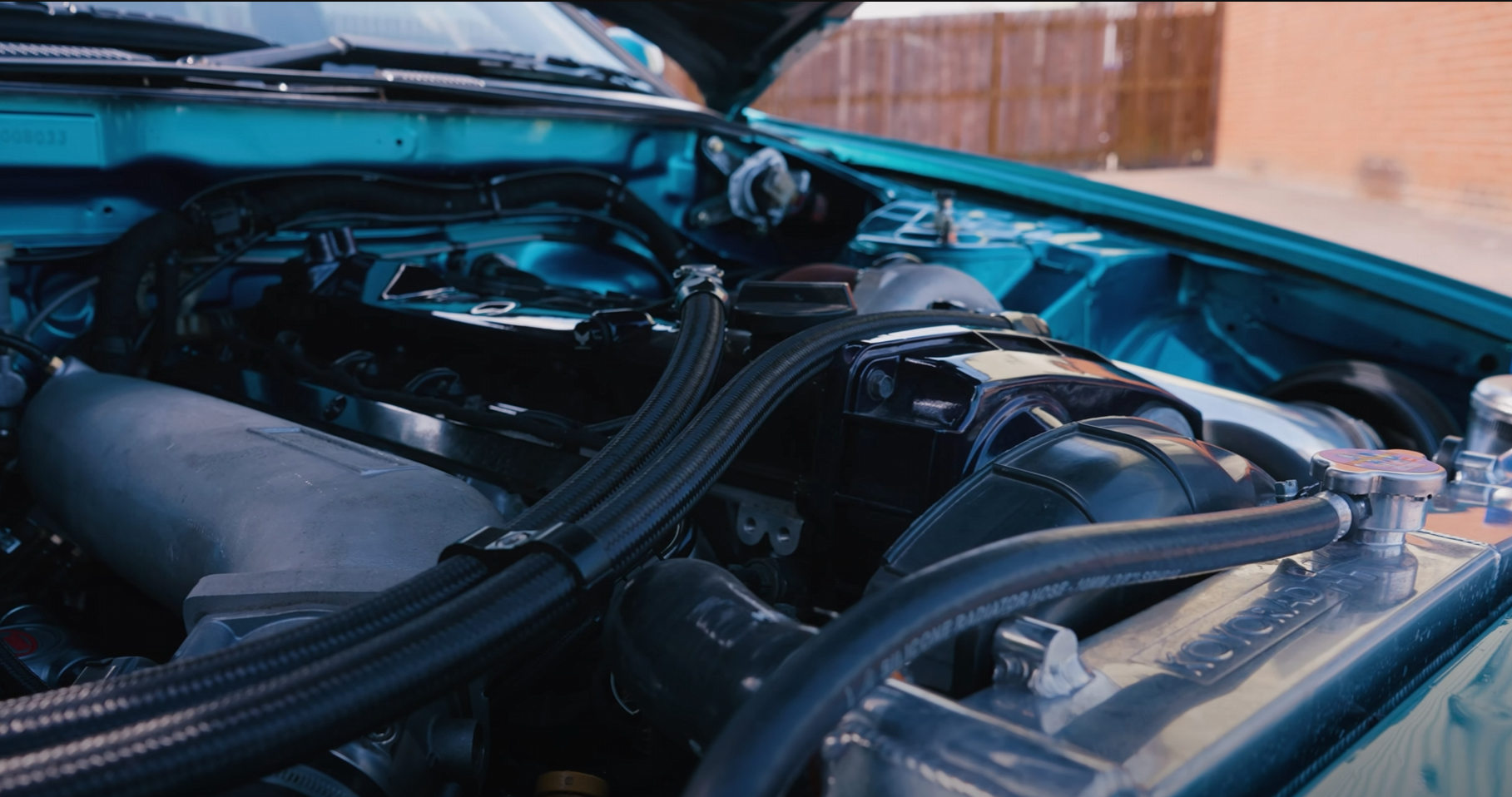 Modified engine bay showing space planning around breather and catch can hose routes