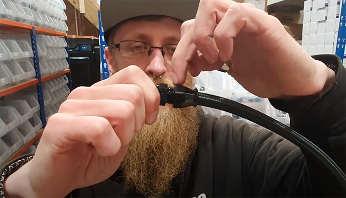 Threading the AN PTFE fitting socket onto the fitting body by hand