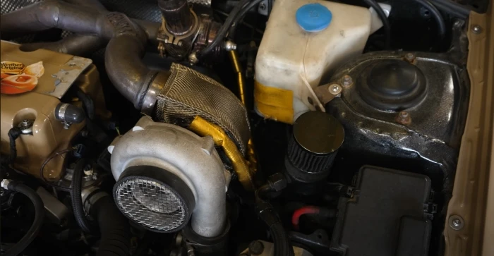 Scott's turbo Honda Concerto engine bay with turbo blanket fitted near the washer bottle