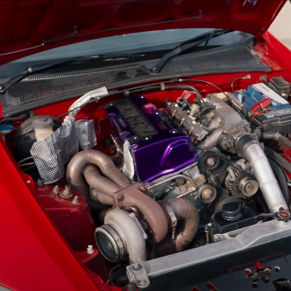 Custom aluminium heat shield protecting nearby parts from exhaust heat in a turbo K-swap Honda S2000 engine bay