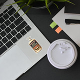 Silence of the Lambs Buffalo Bill body lotion sticker applied on laptop next to coffee cup in workspace