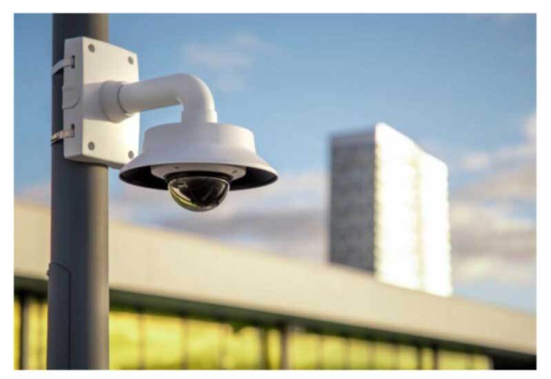 Camera mounted to pole with weathershied, buildings in the background blurred