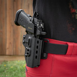 A woman wears a black GRITR OMNI Holster for Staccato P, positioned OWB for secure and accessible carry