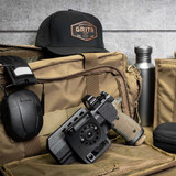 GRITR OMNI Holster for Sig Sauer P320 lies inside an open GRITR soft pouch alongside a GRITR Titanium Mug and GRITR Earmuffs