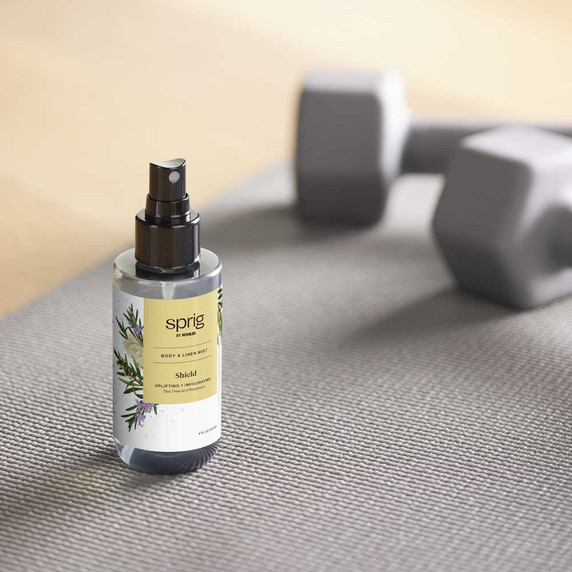 Shield Body & Linen Mist, Full Size next to workout equipment