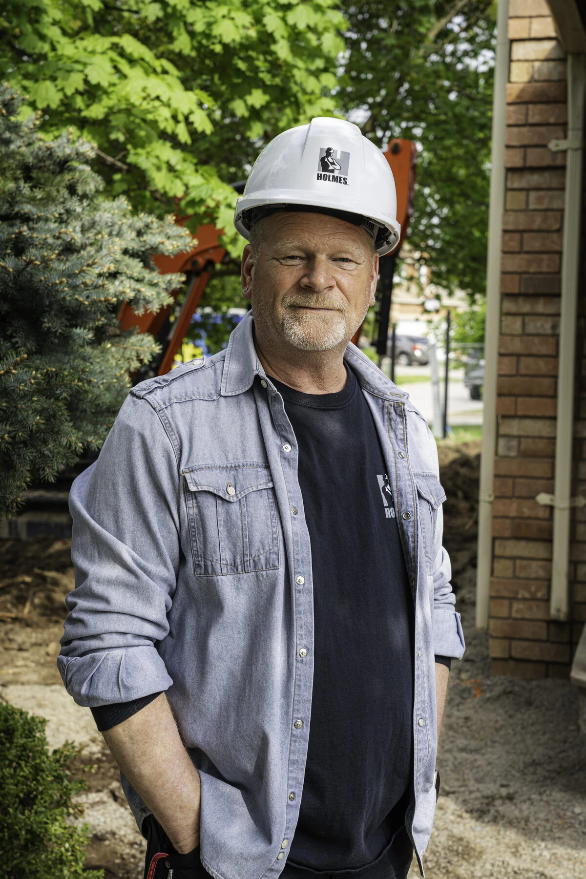 Mike Holmes on a job site wearing a Holmes hard hat