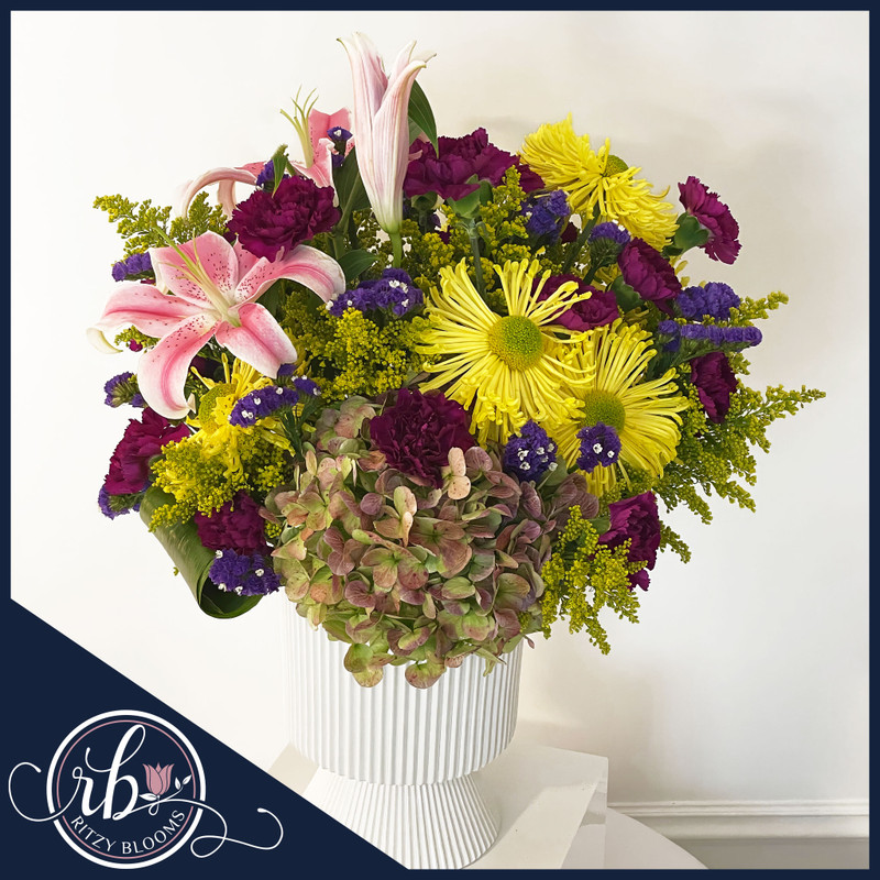 Bright and bold spring floral arrangement with pink Oriental lilies, yellow spider mums, hydrangeas, and accent flowers in a white vase – Ritzy Blooms