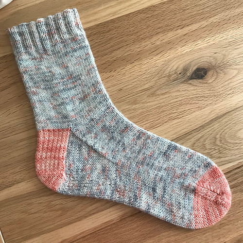 A hand-knitted sock with contrasting heel and toe