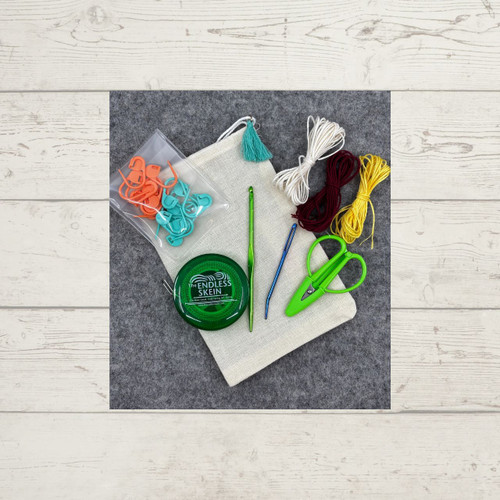 Essentials Notions Kit, which includes a measuring tape, scissors, a fix-it tool, locking stitch markers, a darning needle, and some cotton thread