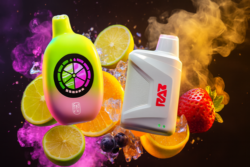 The photo shows two colorful vape devices surrounded by fruit slices, ice cubes, and clouds of vapor. The device on the left has a gradient design blending green and pink, with a circular citrus-like pattern illuminated on its front. The device on the right is sleek and white, featuring a bold red “RAZ” logo and two green indicator lights near the bottom. Around them are lemon and orange slices, strawberries, blueberries, and ice, set against a vibrant backdrop of purple and orange smoke, creating a lively and refreshing atmosphere that emphasizes fruity flavors.