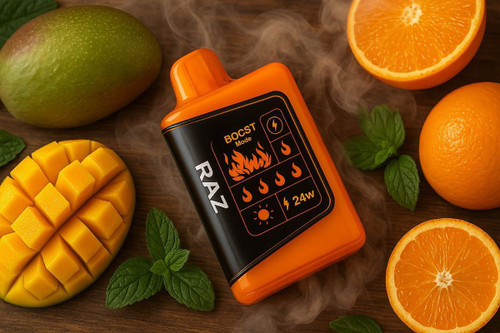 The image shows a disposable vape with a black label lying on a table. Around it are one whole mango, half a mango, and oranges, whole and cut. There are also mint leaves and light smoke around the vape.