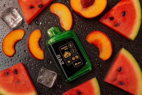 The image features a green disposable vape device labeled "RAZ" placed on a wet surface, surrounded by slices of watermelon, peach, and ice cubes. The vape device has various symbols and text on it, including "BOOST," a lightning bolt, a flame, a sun, and "24m." The composition suggests a refreshing and flavorful experience, possibly highlighting the fruity and cooling aspects of the vape.