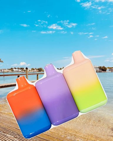 3 disposable vapes on a beach background