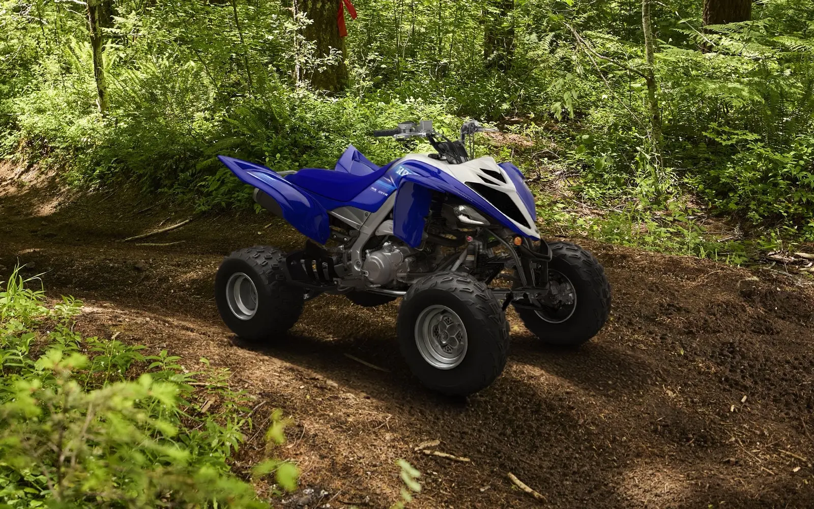 2027 Yamaha Raptor 700R sport ATV riding through a wooded trail