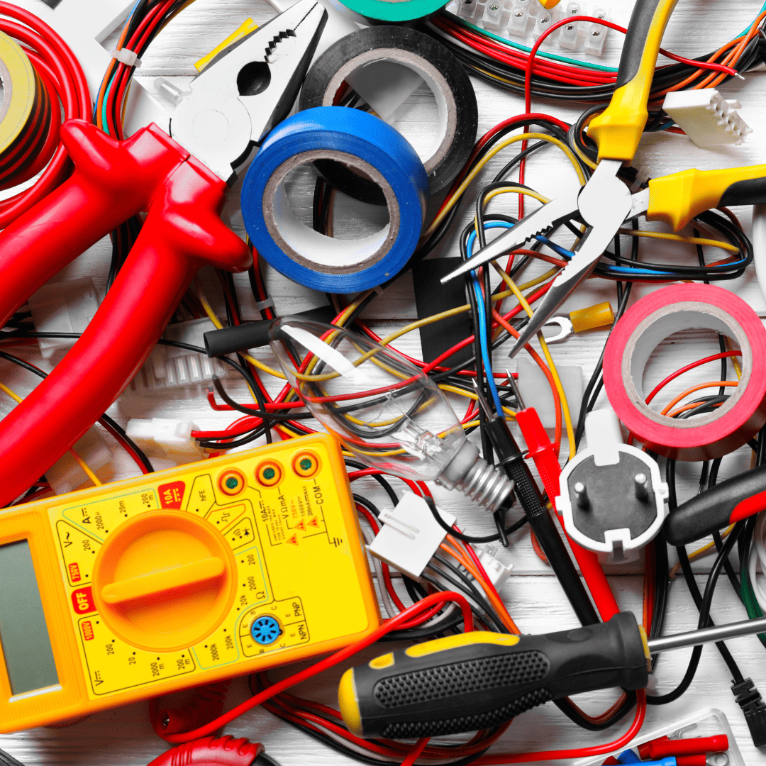 Electrical tools and components including red pliers, multimeter, electrical tape, wires, and various electrical components