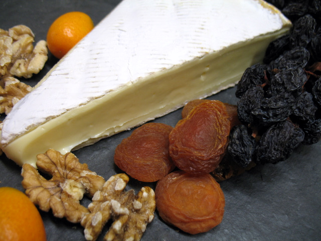 brie with kumquats, walnuts, raisins on the vine and apricots