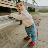 Baby wearing NBA Team Bulls, Benny The Bull Soft Soles in Red, learning to stand