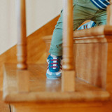 Baby boy wearing Jasper Soft Soles in Grey, climbing the stairs