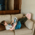 Girl wearing Elisa Rabbit Slippers laying on the couch reading a book