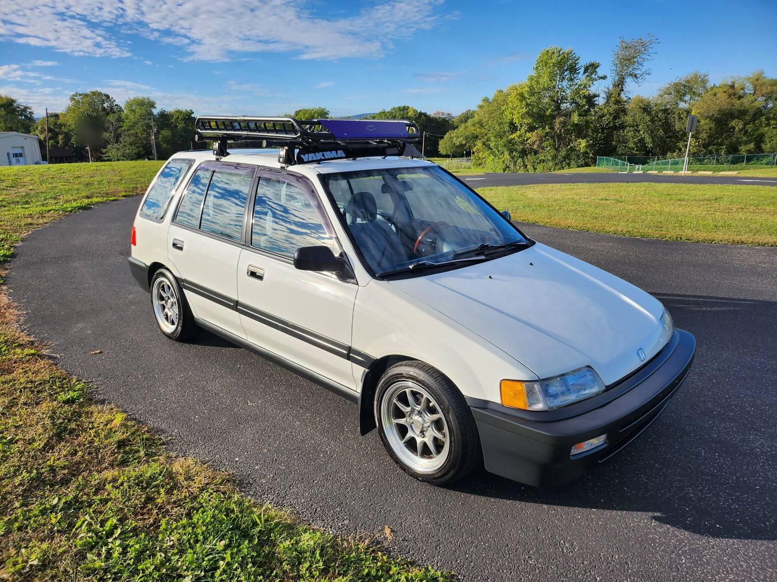White Honda Civic wagon with a roof rack, freshly detailed