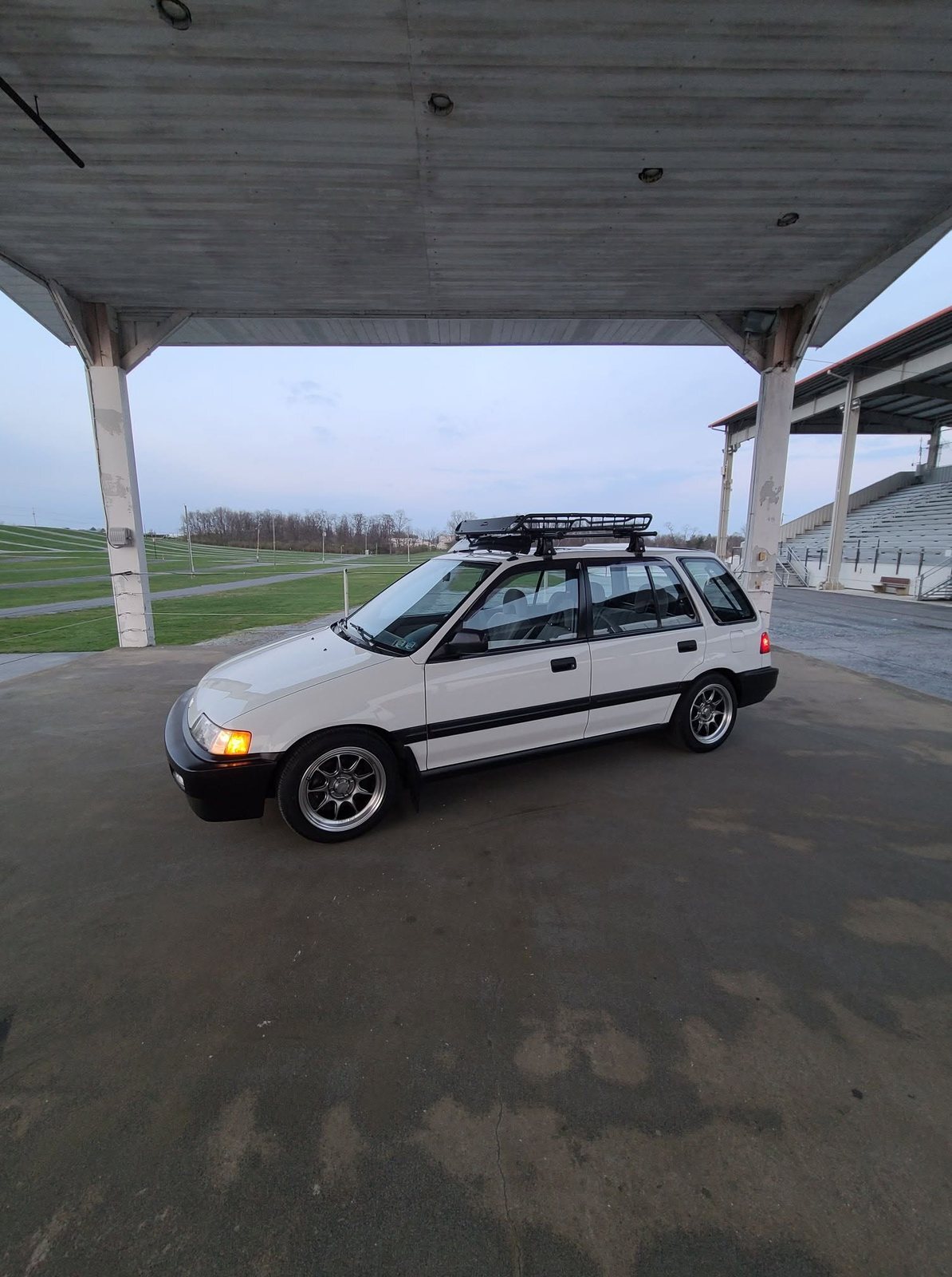 White Honda Civic wagon parked under a covered grandstand