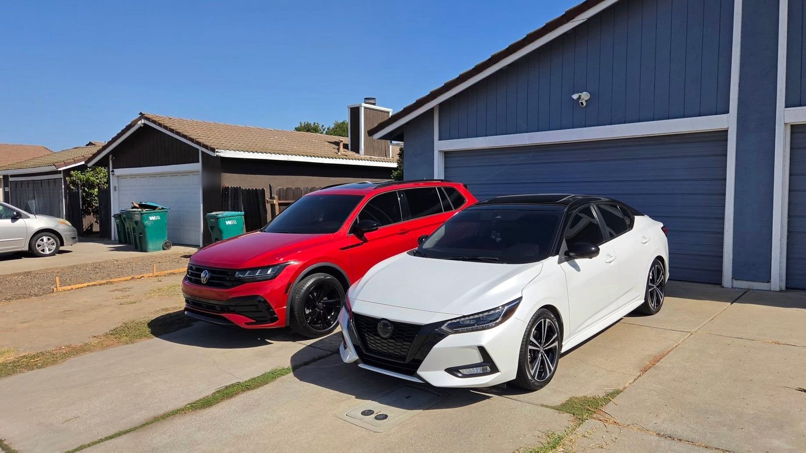 Red crossover and white sedan parked side by side, freshly detailed