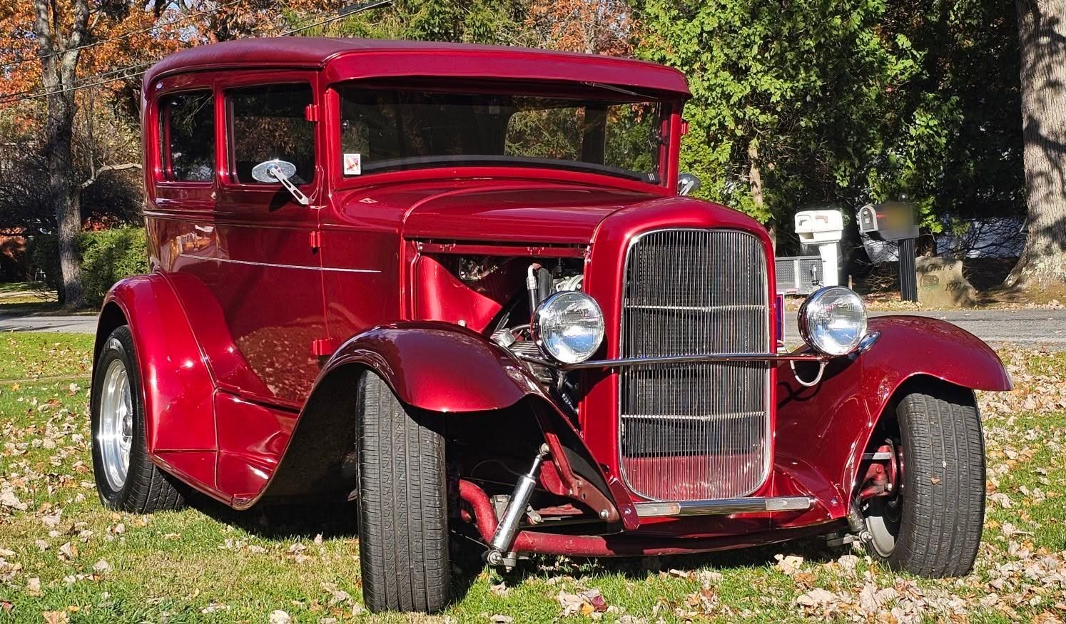 Red classic hot rod parked on the grass