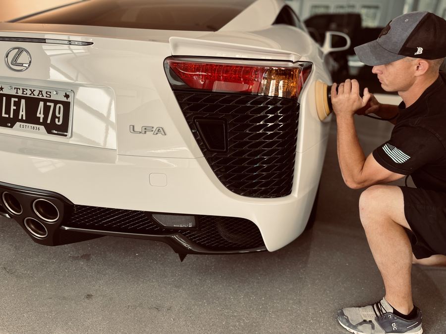 Landon Crawford polishing the rear of a white Lexus LFA in the studio