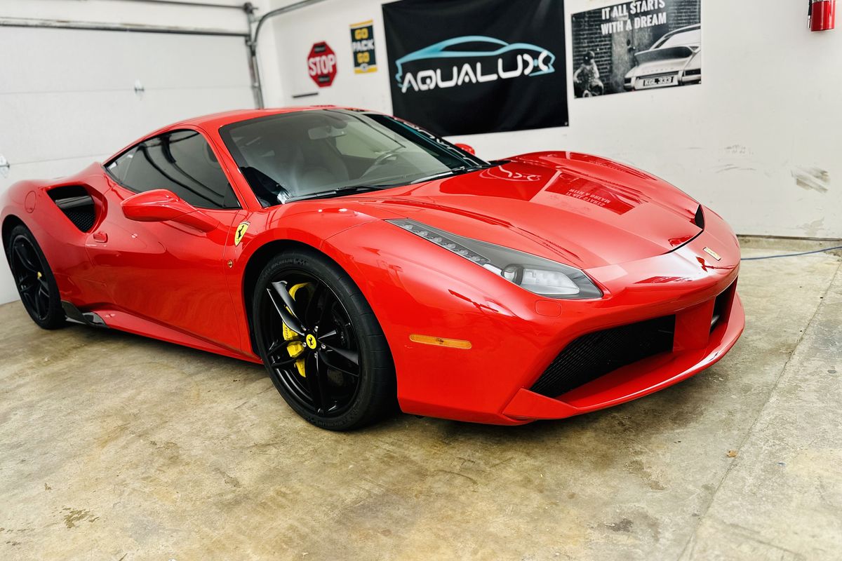 Red Ferrari 488 in the Aqualux Auto Detailing shop under the Aqualux banner