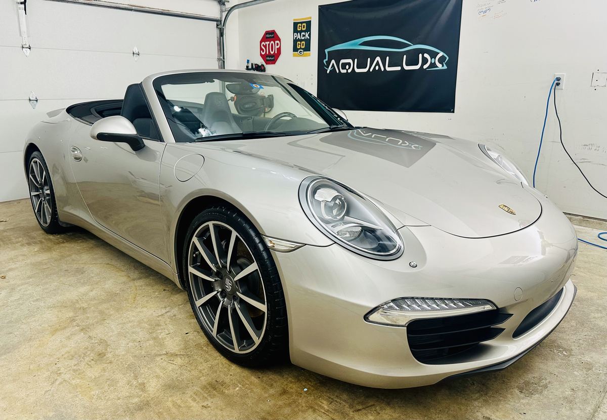 Silver Porsche 911 convertible under the Aqualux banner