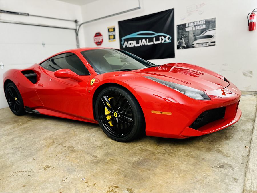 Red Ferrari under the Aqualux banner in the detailing shop