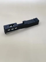 Image of the Armor Black CERAKOTE® Kineti-Tech LWP Slide for Glock® 43/43X with window cuts, deep rear serrations, and RMSc/Holosun K‑series optic compatibility for reduced recoil and faster target re‑acquisition.

Rear-angle view of the Armor Black Kineti-Tech Lightweight Ported slide for Glock with window cuts and RMSc/Holosun K optic cut.