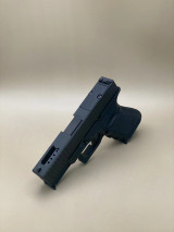 Side‑angled product image displaying the Kineti‑Tech Ported slide with 3, 6, and 12 o’clock lightning cuts, RMR® optic cut, and stainless steel barrel ports, highlighting its lightweight, performance‑driven design.

Side angled view of Kineti‑Tech Ported Black slide for Glock 19 Gen 3 with lightning cuts and RMR optic cut.