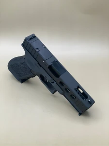 Angled view of the Kineti-Tech LWP (Lightweight Ported) Complete Slide for Glock® 17 Gen 5 in Armor Black CERAKOTE®. Features lightening window cuts for reduced weight, large gas‑venting port for the ported barrel, and an RMR optic. Designed to reduce muzzle flip and speed up follow‑up shots.

Armor Black Kineti-Tech LWP Slide for Glock 17 Gen 5 with ported design and RMR optic cut.