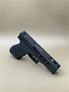 Angled view of the Kineti-Tech LWP Complete Slide for Glock® 17 Gen 3 in Armor Black CERAKOTE® finish. Features lightening window cuts for weight reduction, large port for gas venting, and RMSc optic cut for micro red dot compatibility.

Armor Black Kineti-Tech LWP Slide for Glock 17 Gen 3 with lightening cuts, ported design, and RMSc optic cut.
