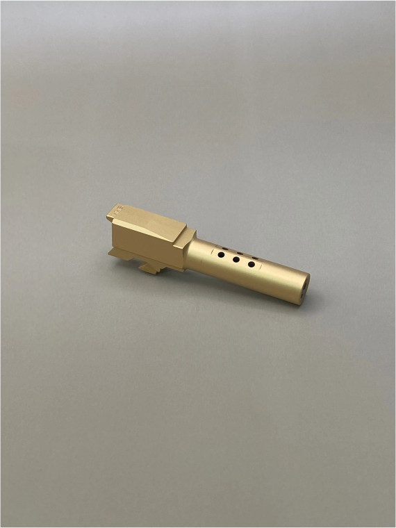 Front-facing view of a Gold TiN Glock 43/43X Ported barrel on a light background, displaying the muzzle opening and smooth exterior finish.

Front view of a Gold TiN Glock 43/43X barrel against a light background.