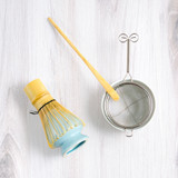 Hand sifter and scoop and whisk on blue whisk holder