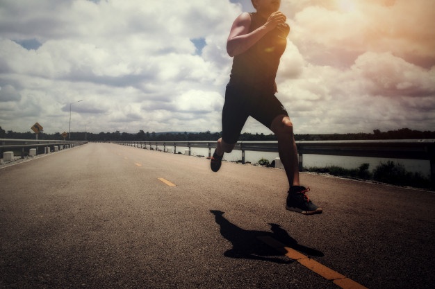 Shot of man in mid-air as he runs down the road