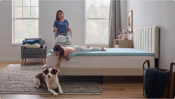 kid laying on mattress petting dog