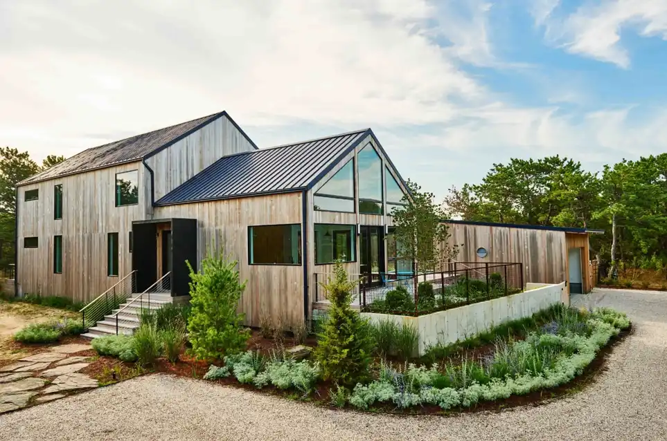 Atelier 216 showcasing Hamptons-inspired interiors with salvaged pine beams and coastal vegetation.