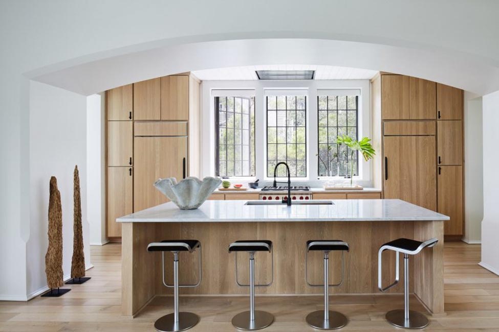Open-plan kitchen at Harrison Residence with custom light timber cabinetry, black hardware and marble island — a hallmark of Hamptons style architecture Australia by Jeffrey Dungan Architects
