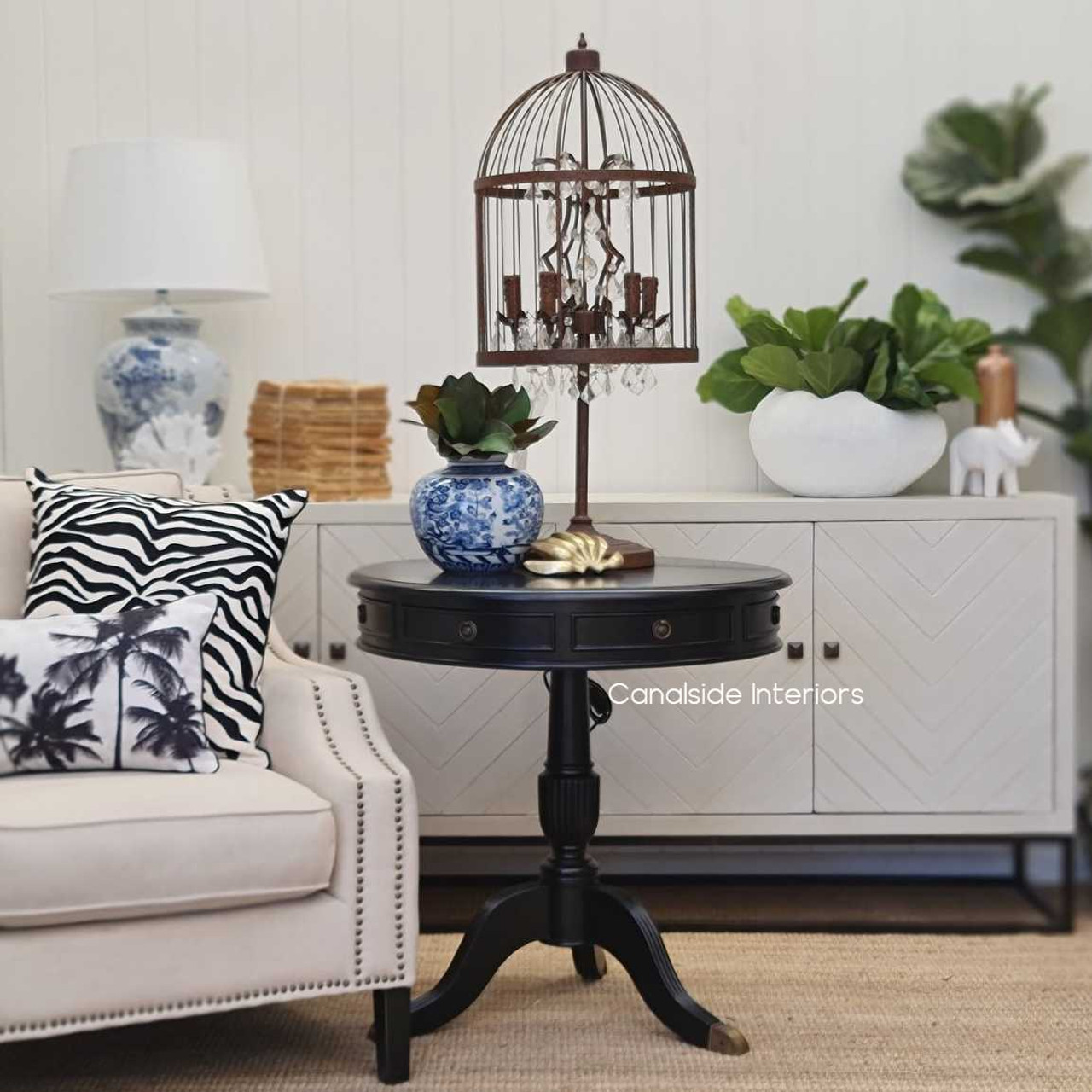 Lifestyle image depicting the lamp in a coastal living room setting, where its unique birdcage design serves as a stunning focal point.