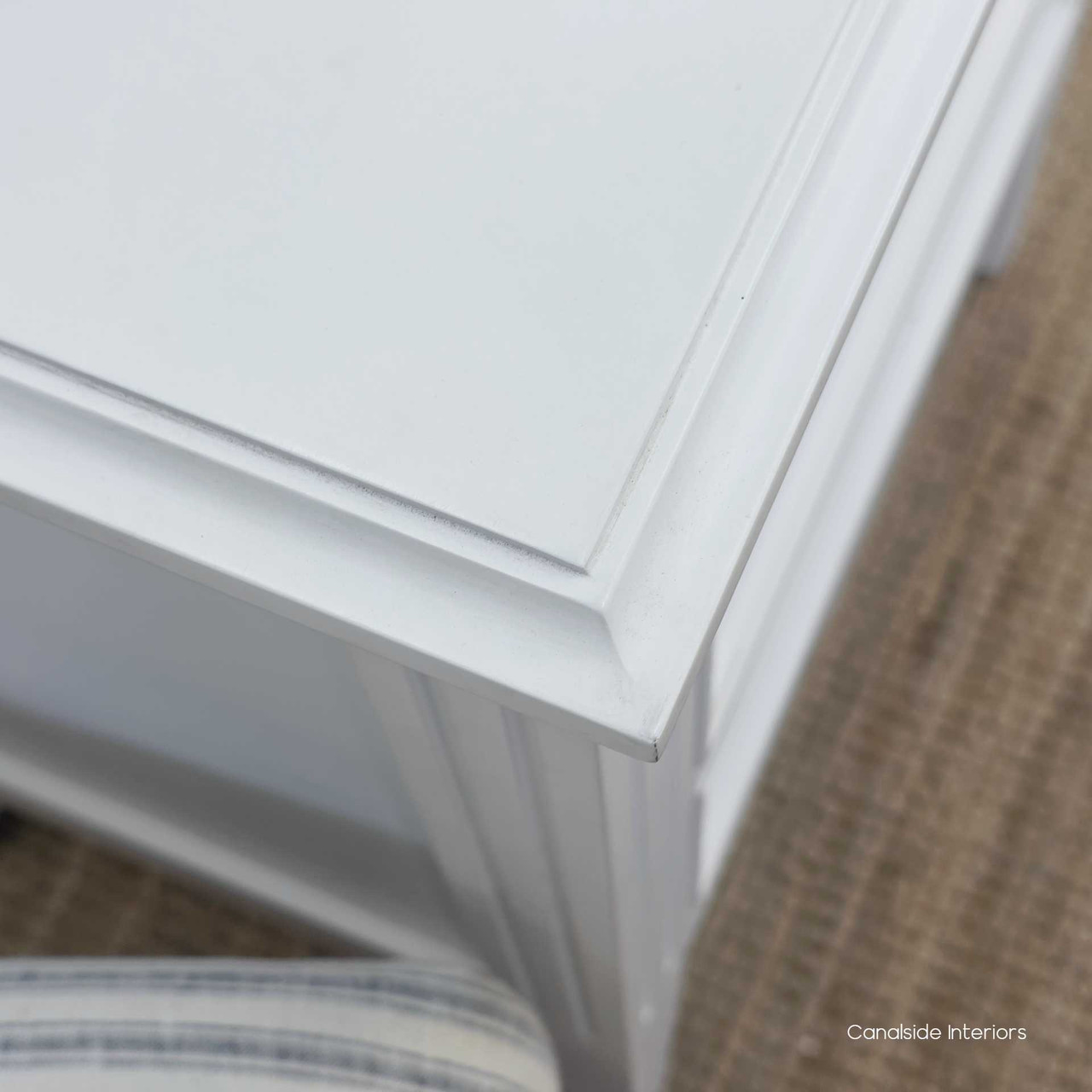 Close-up of the moulding detail along the drawer frame of the Peninsula white bedside.