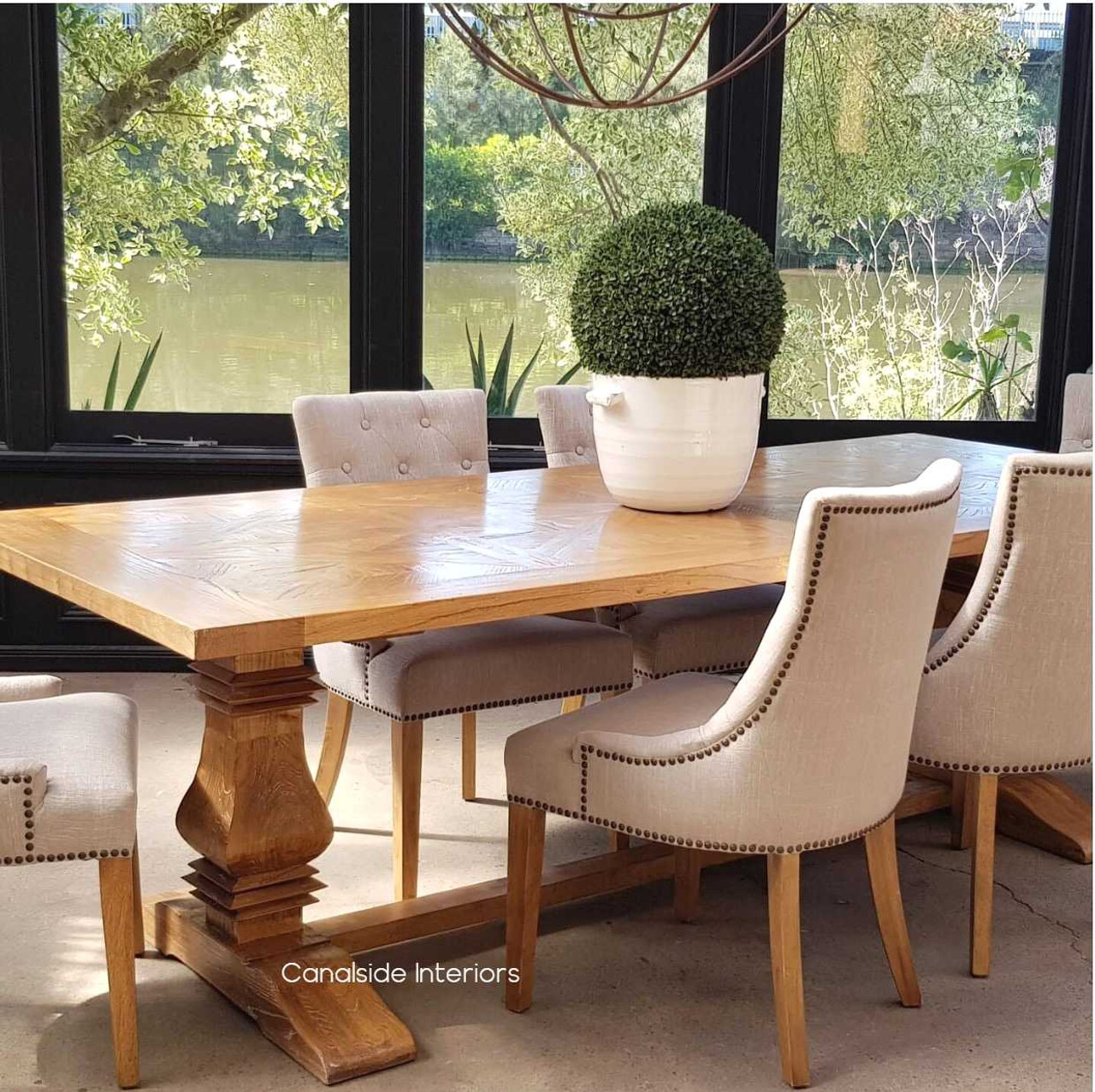View of the Artisan Parquetry Top Dining Table, highlighting its recycled timber and elegant canon legs at Canalside Interiors.
