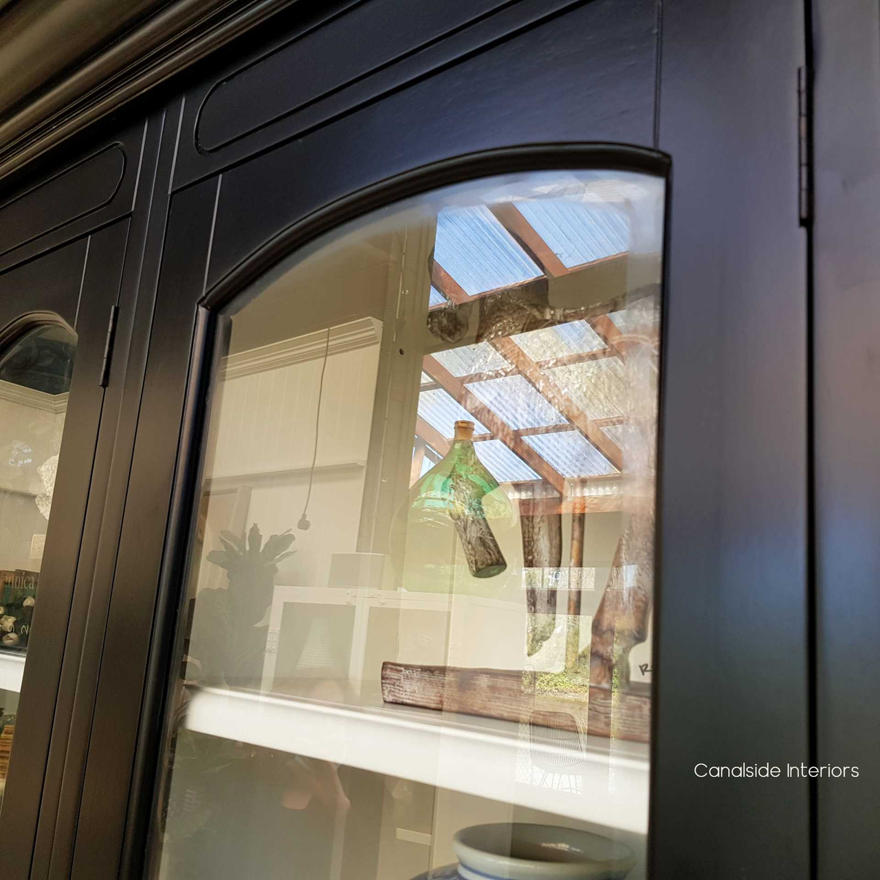 Canalside Interiors' Key Largo Unit, with its glass doors and sleek detailing, is the perfect backdrop for displaying treasures in a coastal dining room