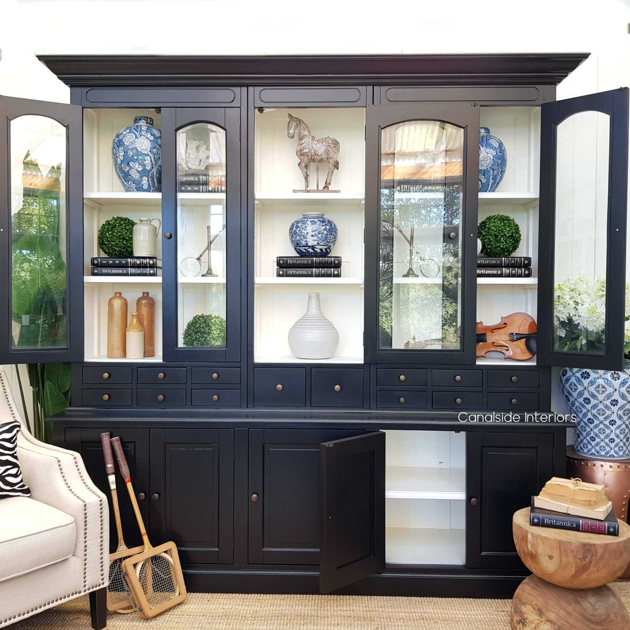 Crafted by Canalside Interiors, this distressed black Key Largo Unit with a contrasting white interior provides an elegant storage solution for your living room