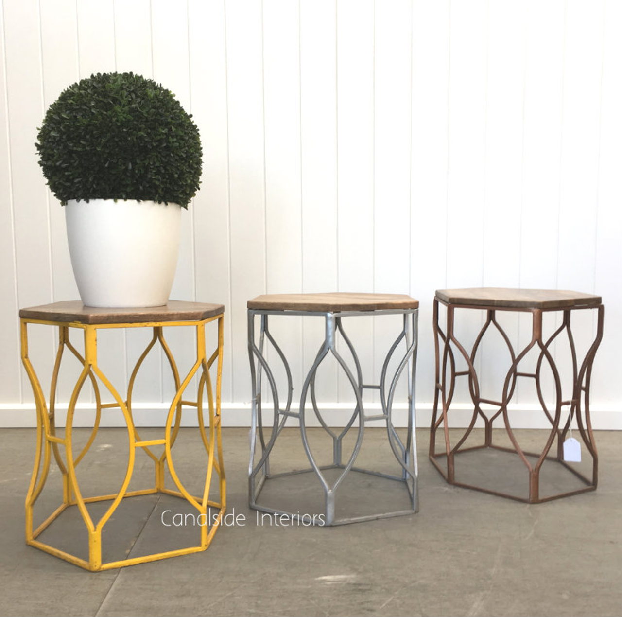 The Braxton Stool by a white pot, illustrating how it can complement Plantation-style decor as a side table or additional cafe seating
