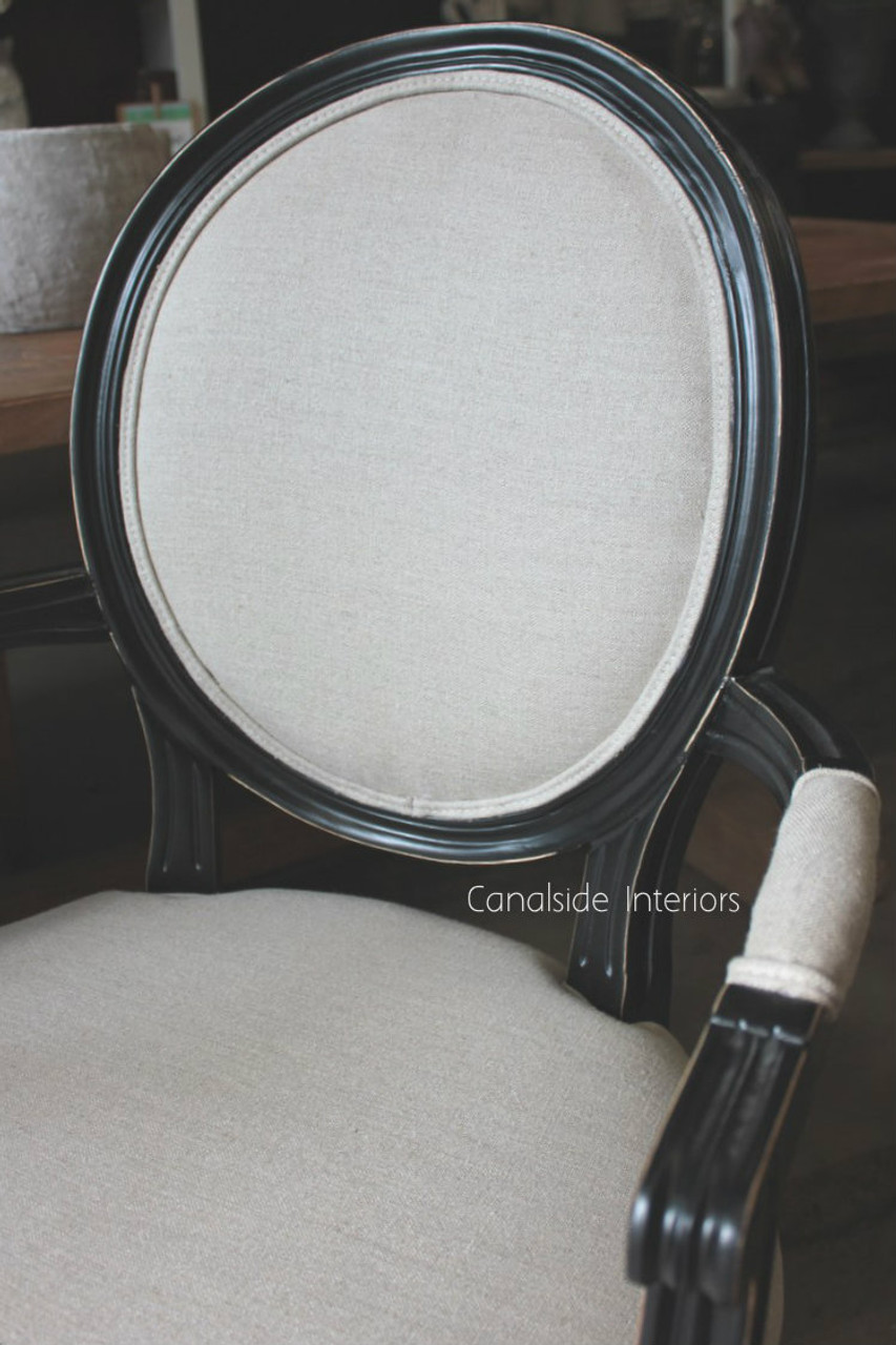 The neutral cream and black Sansa Carver Chair enriches a dining room with its hand-crafted beauty and French aesthetic