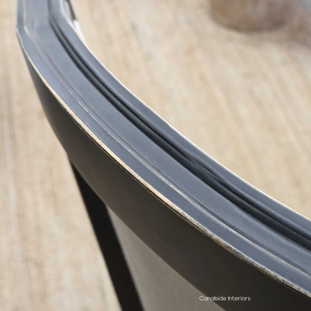 Frame detail highlighting the sculpted backrest design in distressed black.