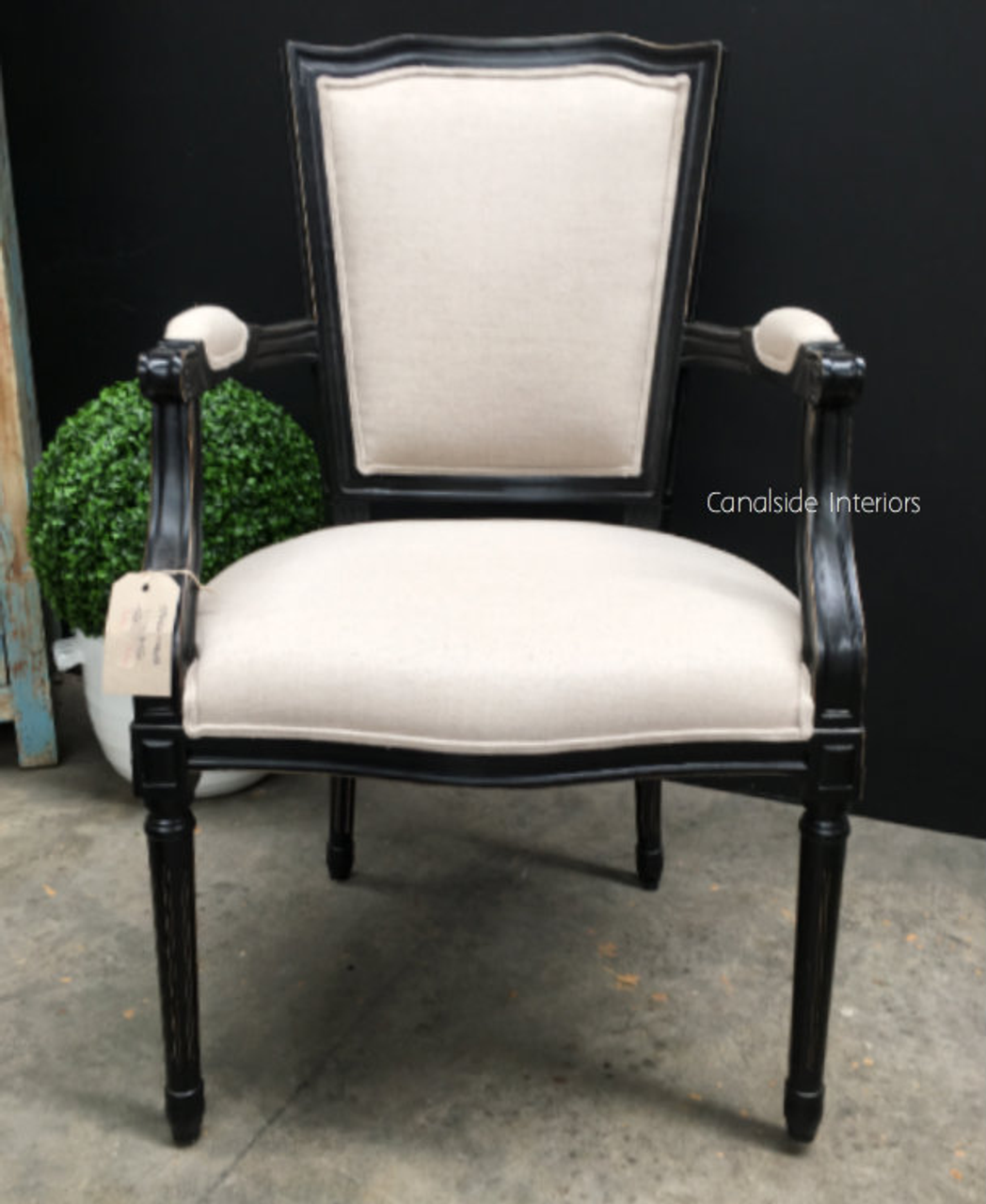Canalside Interiors' Stark Carver Chair in distressed black provides a classic, chic seating option for both modern and traditional dining room